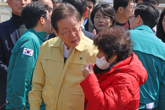 이재명 더불어민주당 대표가 지난 29일 경북 영덕군 영덕읍 노물리에서 산불 피해를 본 주민의 얘기를 듣고 있다. [연합뉴스]